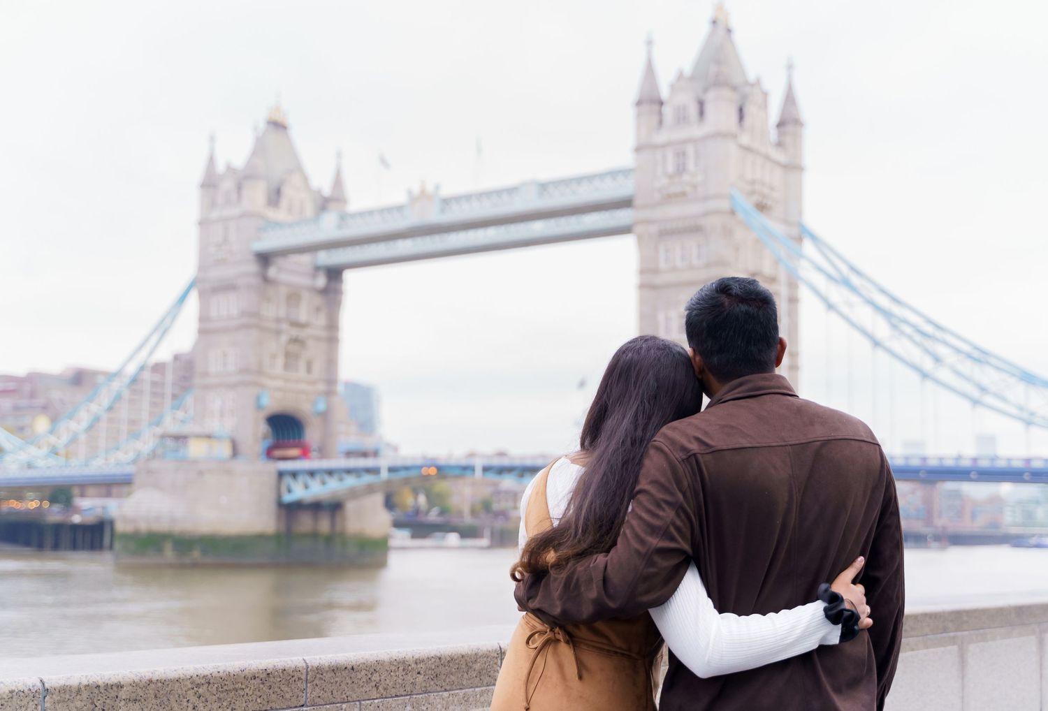 Two people dancing in front of St. Paul's Cathedral in London with modern glass buildings reflecting the iconic dome.