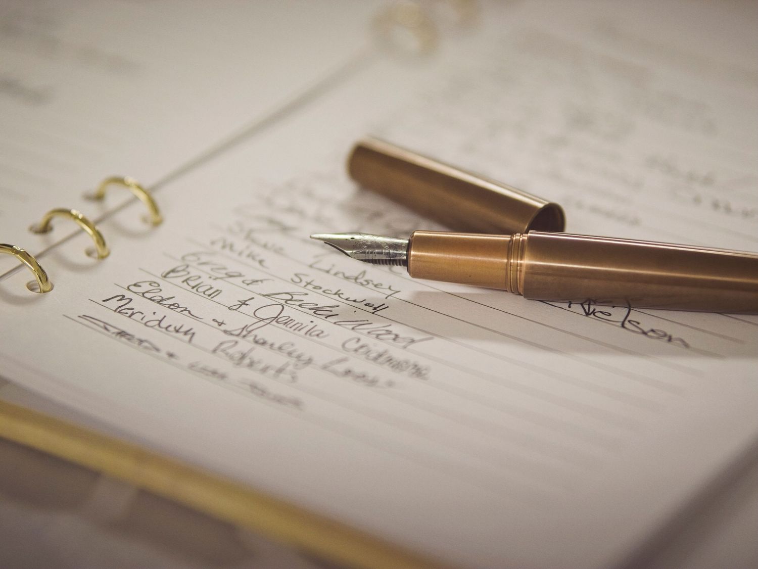 An uncapped fountain pen rests on a guestbook