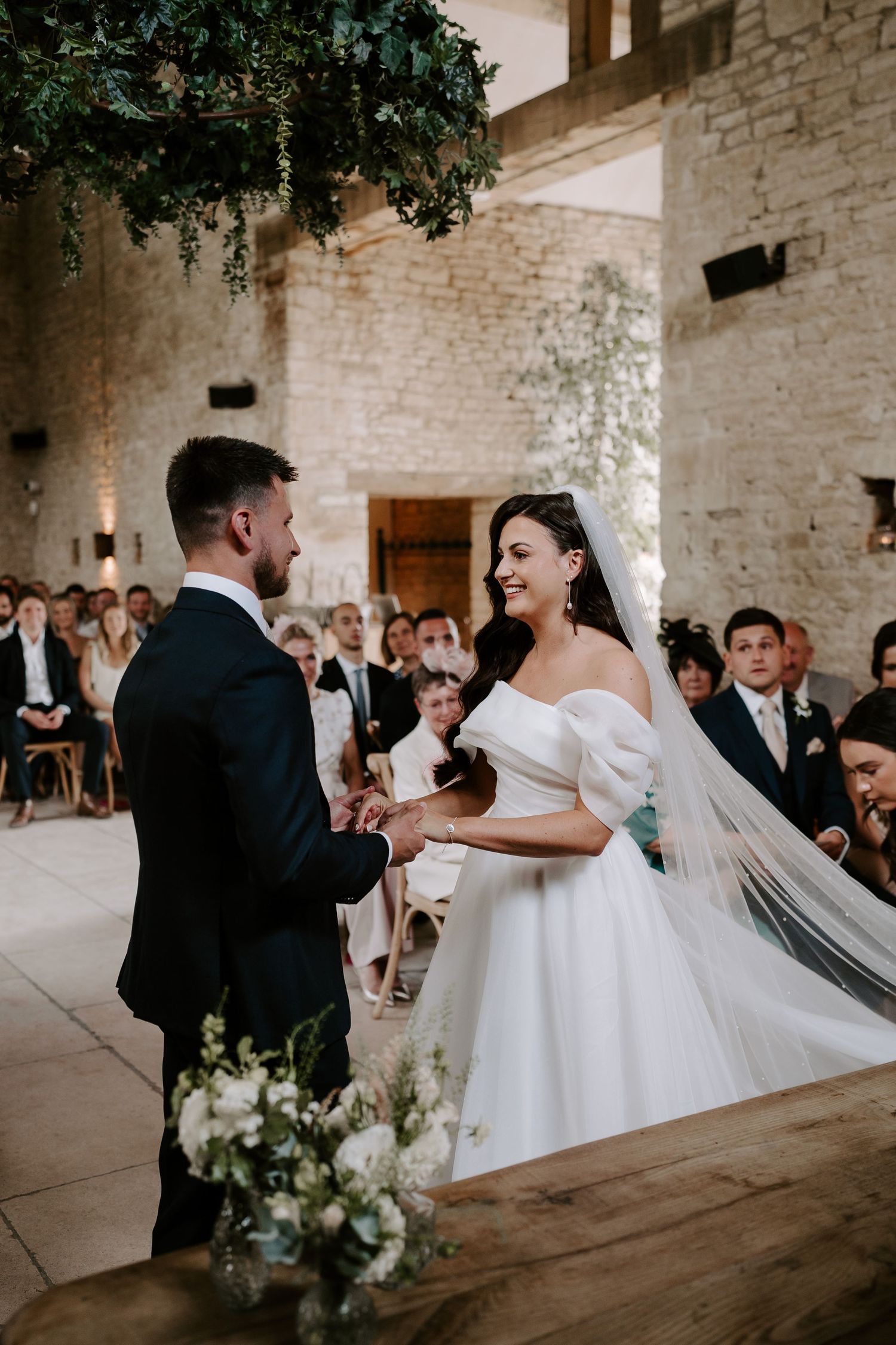 bride and groom holding hands during wedding ceremony at yardspace old gore in cirencester