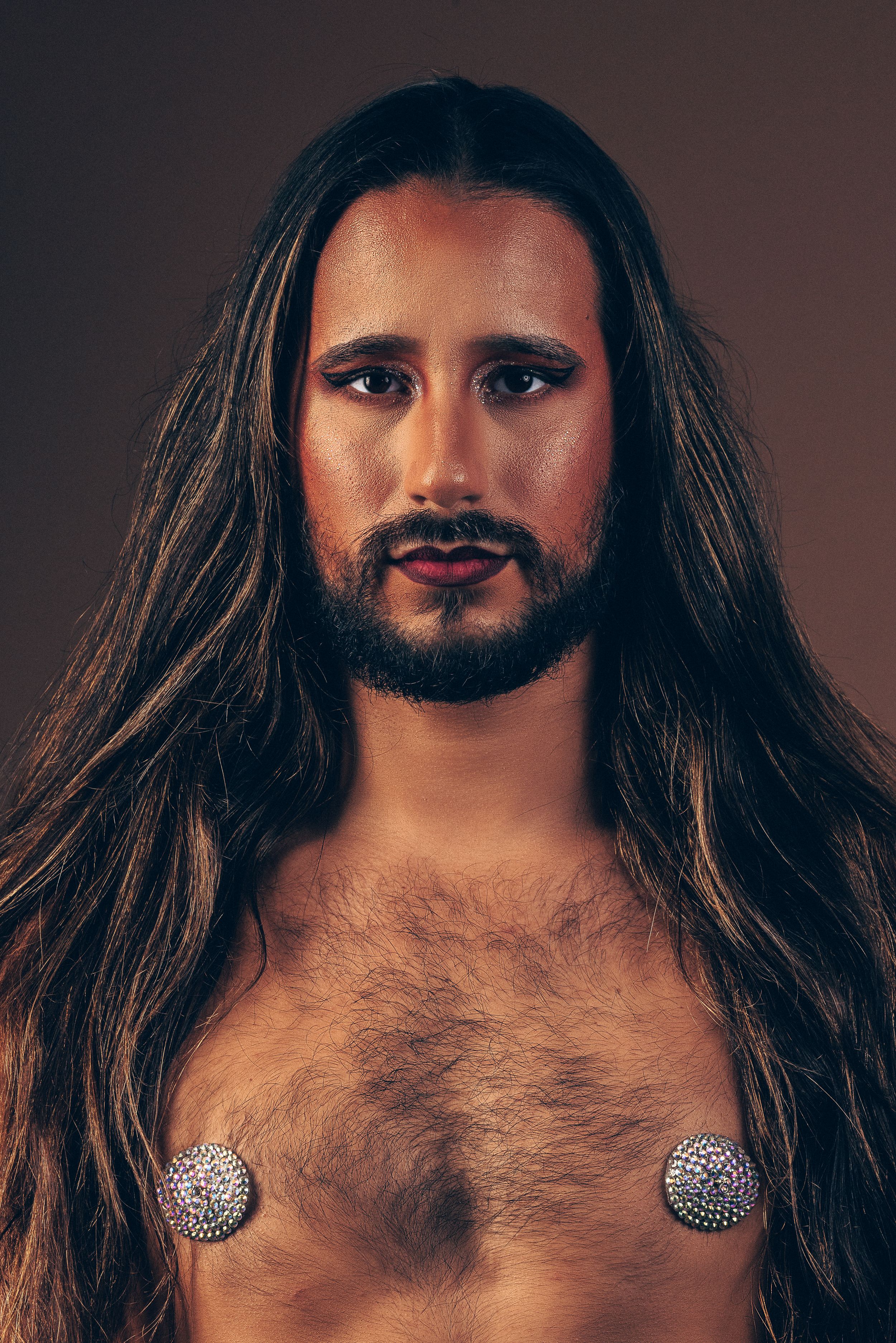 A creative photo composition shows seven profile views of a bearded face with dark hair against a deep brown background.