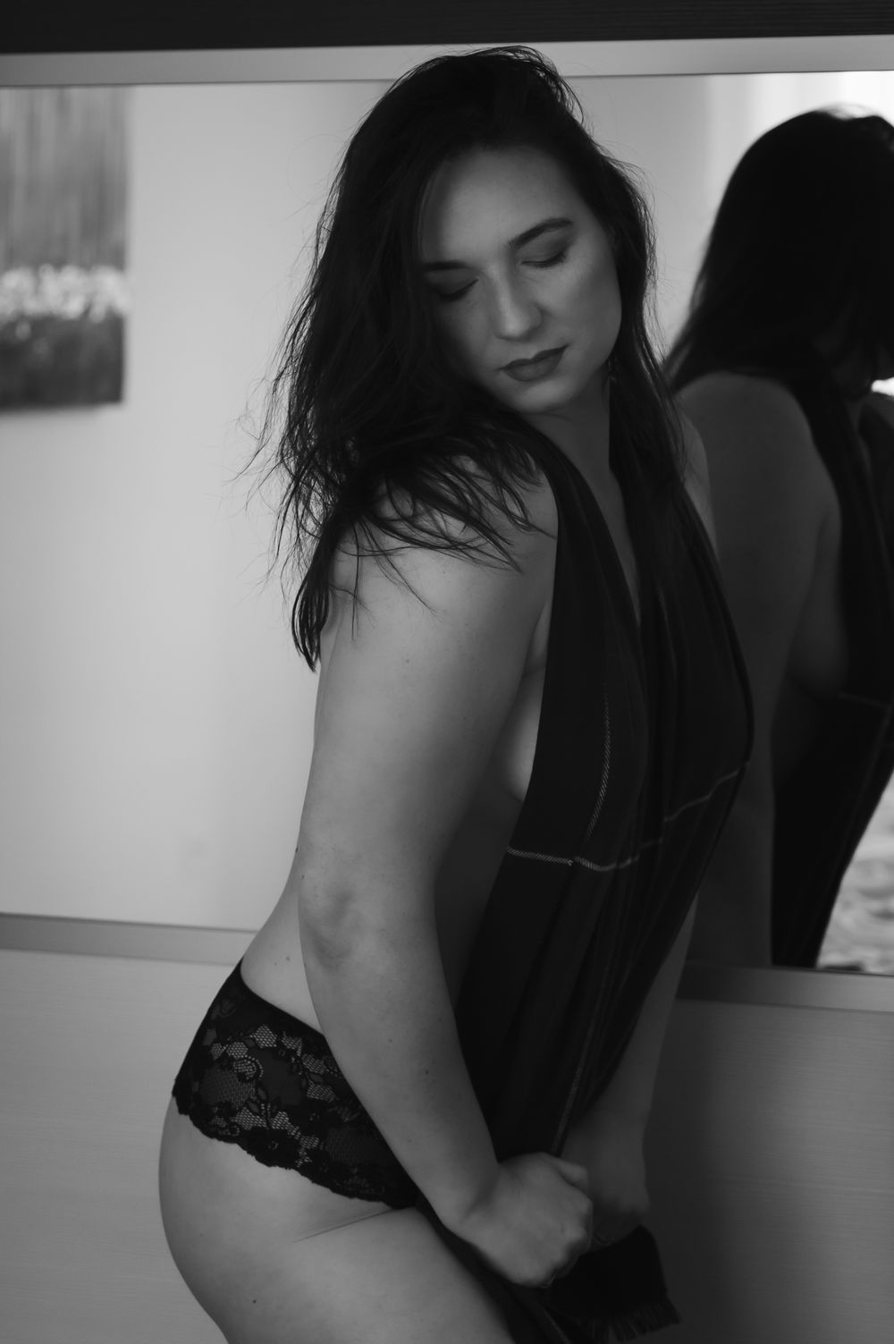 Black and white portrait showing a silhouette against a wall in intimate apparel.