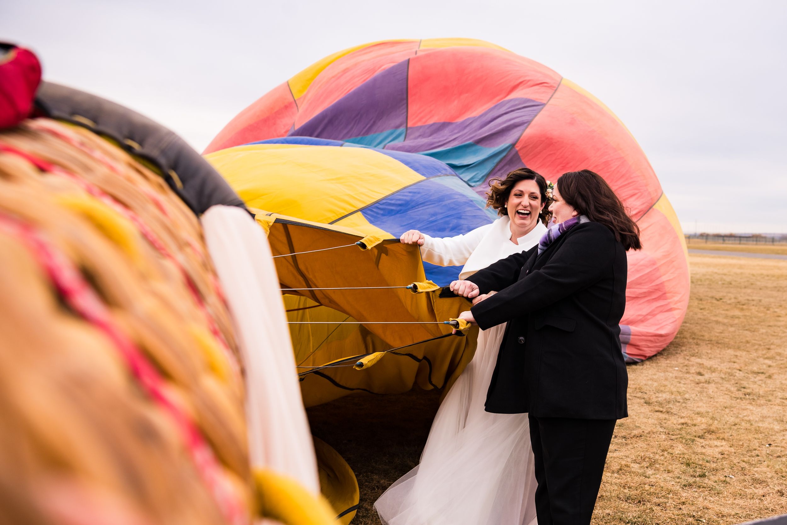 A collection of images showing a hot air balloon landing and being deflated in an open field at sunset.