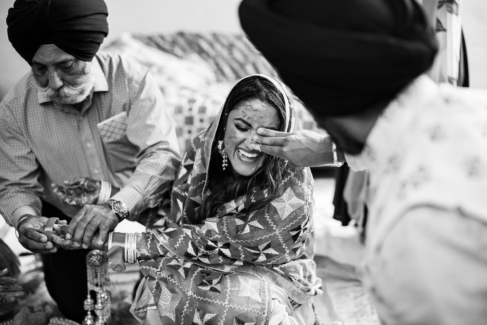 Joyful candid moment of laughter captured in black and white at a social gathering.