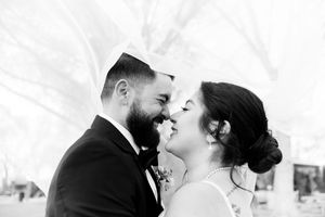 A romantic black and white photo of a couple sharing a tender moment on their wedding day.