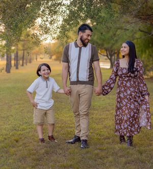 Family walking together in a park during golden hour wearing coordinated brown and floral outfits.