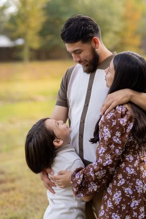 Candid family moments captured in a series of loving embraces during a fall photoshoot outdoors.