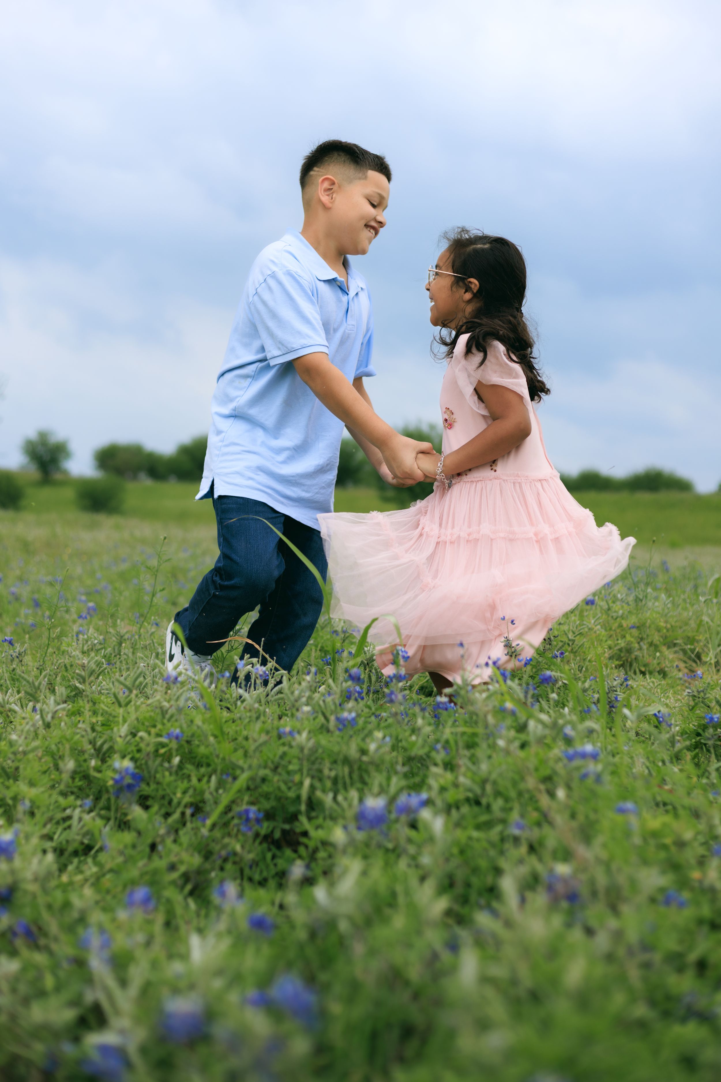 siblings dancing in the blue bonnet fields