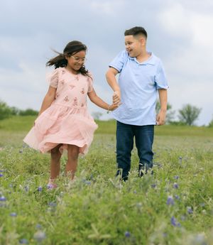 siblings dancing in the blue bonnet fields