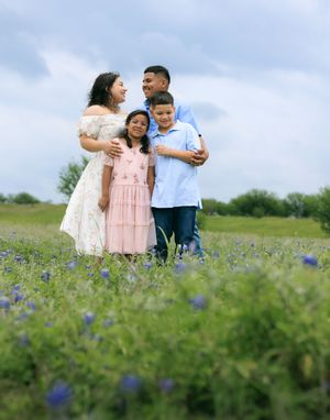 Family session portrait of family posing in the blue bonnet field.