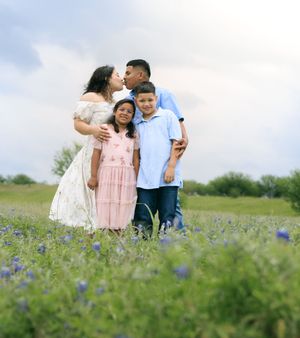 Family session portrait of family posing in the blue bonnet field.