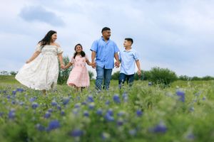 Blue bonnet family session. This beautiful family are all holding hands skipping through the fields of the blue bonnets