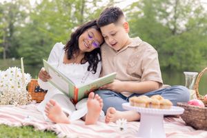 Siblings enjoying some outdoor reading for their picnic time.