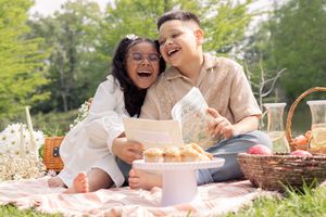 Brother and sister sharing a stories and laugh during outdoor picnic time.