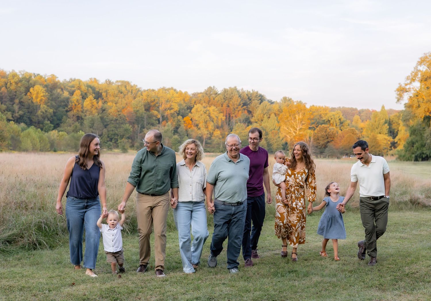 A series of candid family photos showing people walking together in a golden autumn field at sunset.