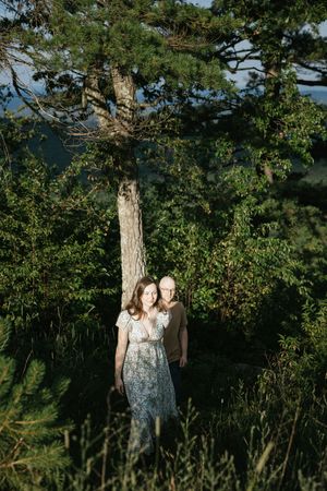 A scenic wooded area with tall trees and lush greenery creates a natural outdoor setting in golden sunlight.