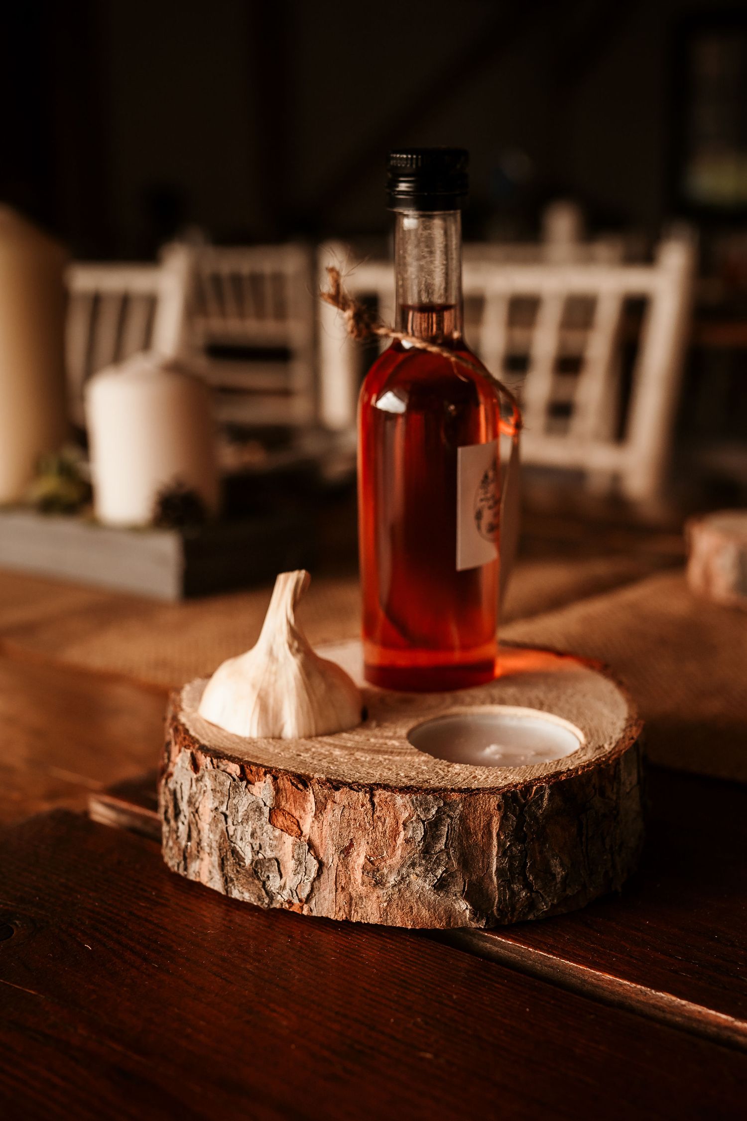 Bottle of rose wine and decorative items displayed on rustic wood slice centerpiece.