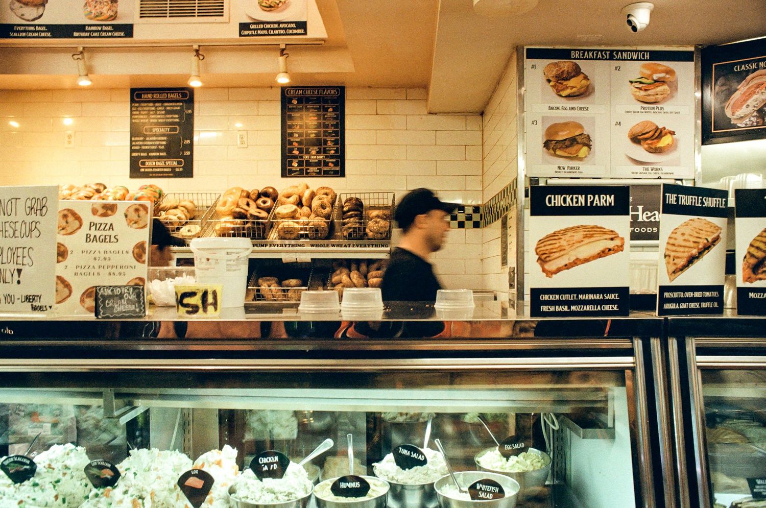 Interior of a deli counter with menu boards and food displays.