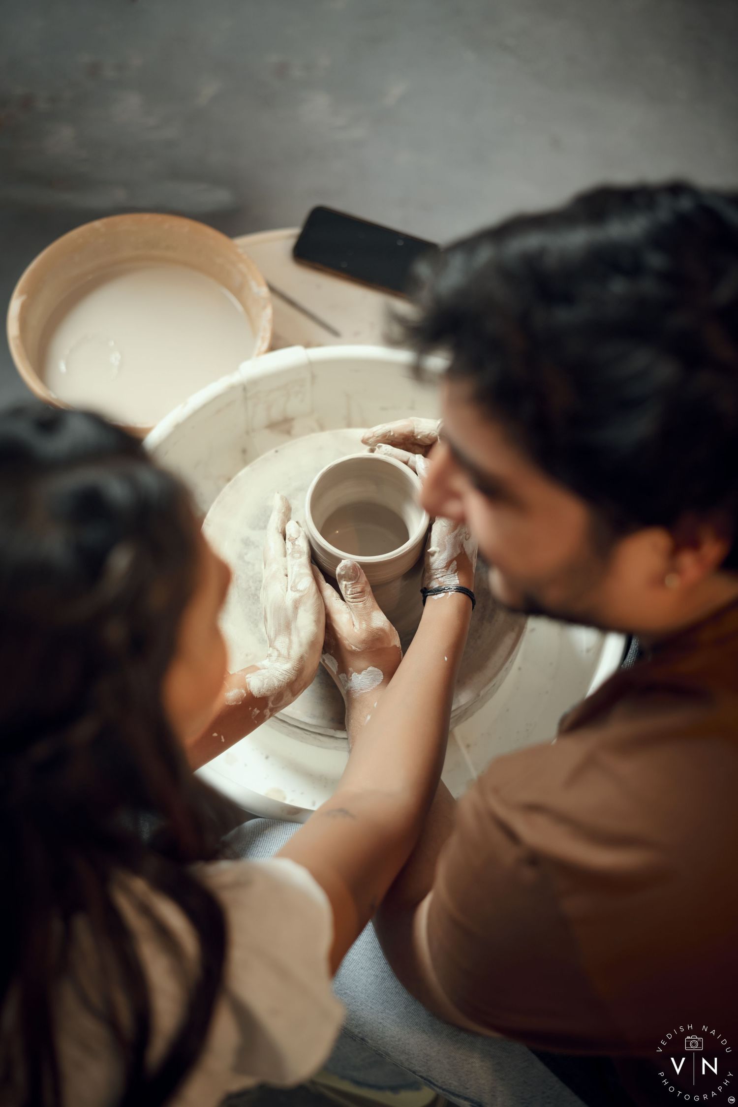 A couple standing close under an Pottery , surrounded in a romantic and intimate moment.