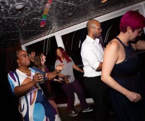 People dancing and enjoying themselves at a nighttime celebration event.