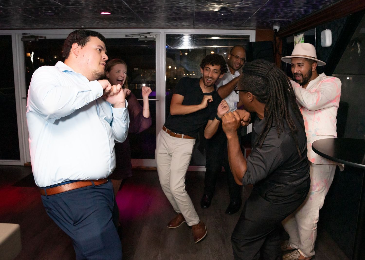 Dance partners move across a dark dance floor during a social dance gathering.