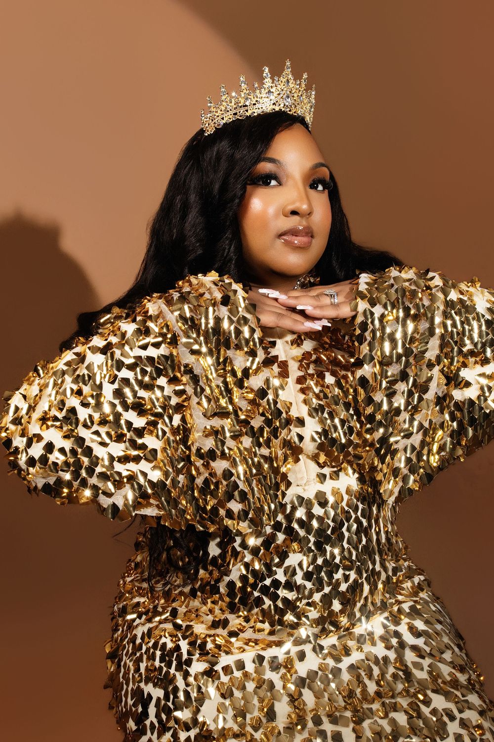 Celebratory photo series featuring a sparkling gold sequined outfit and crown against warm lighting.