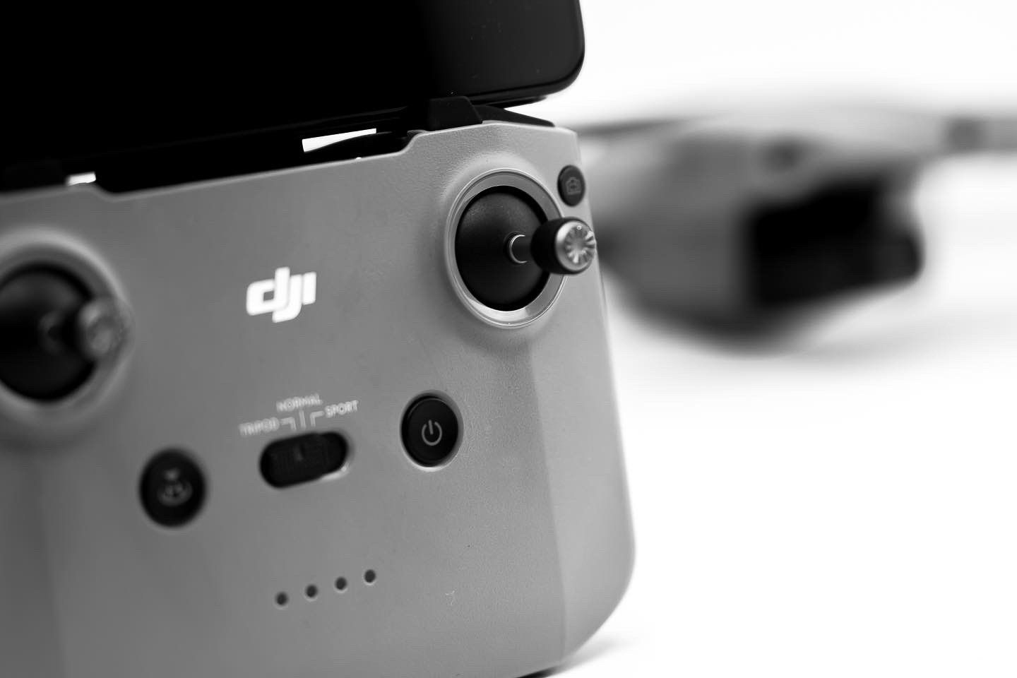 DJI drone controller detail showing joystick and status indicators.