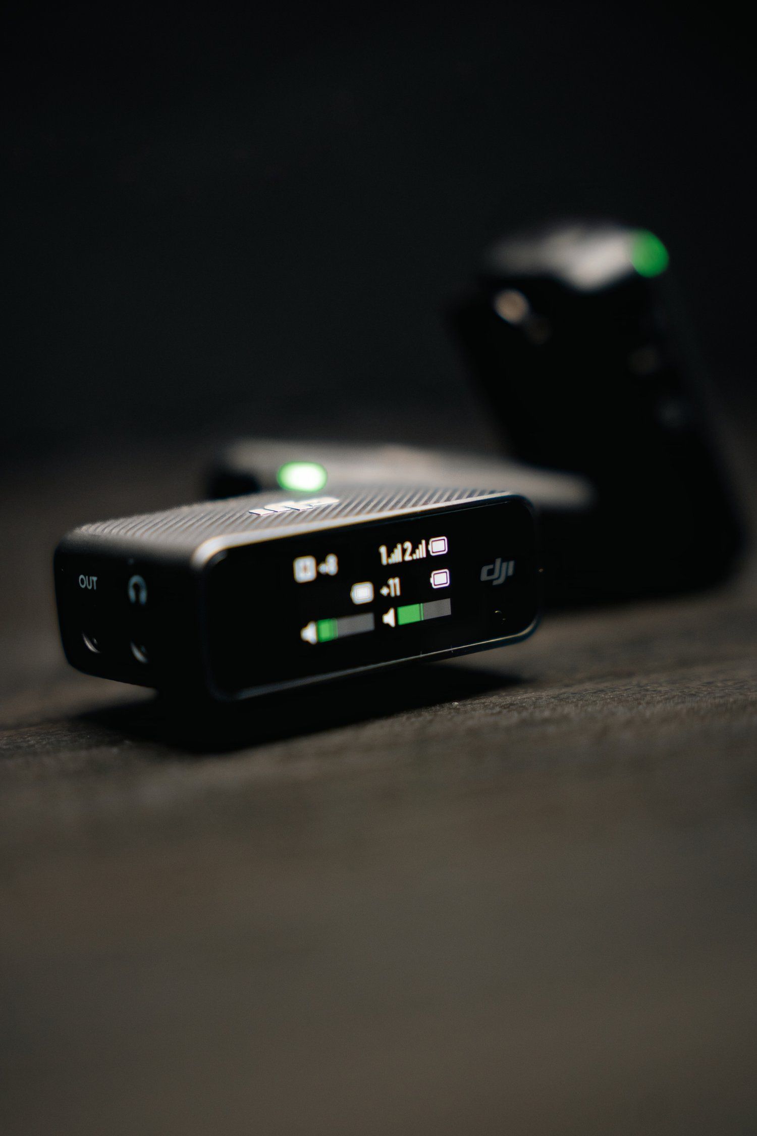 Close-up of DJI wireless transmitter display screen showing signal strength indicators.