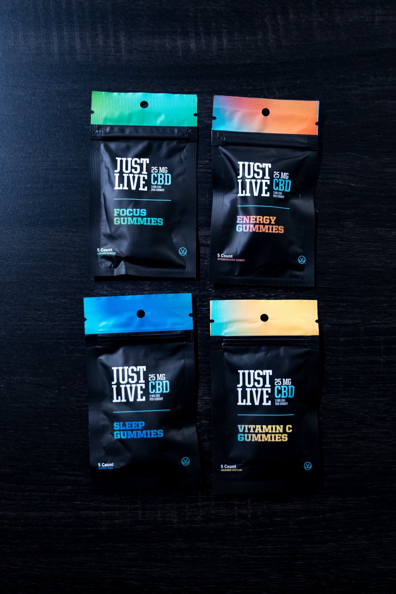 Four Just Live supplement packets with colorful headers arranged on black background.