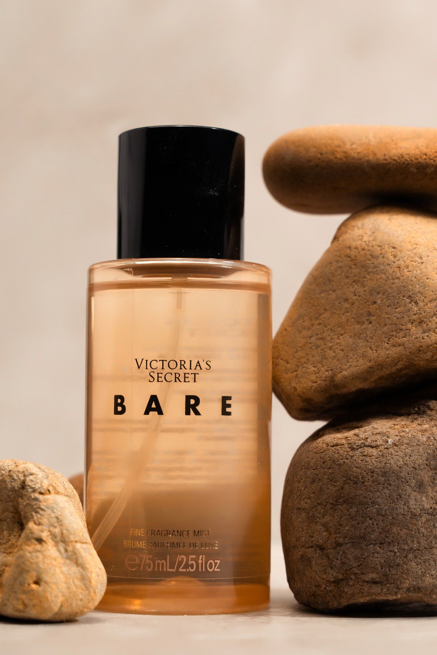 Victoria's Secret Bare fragrance bottle displayed with natural stones against neutral background.
