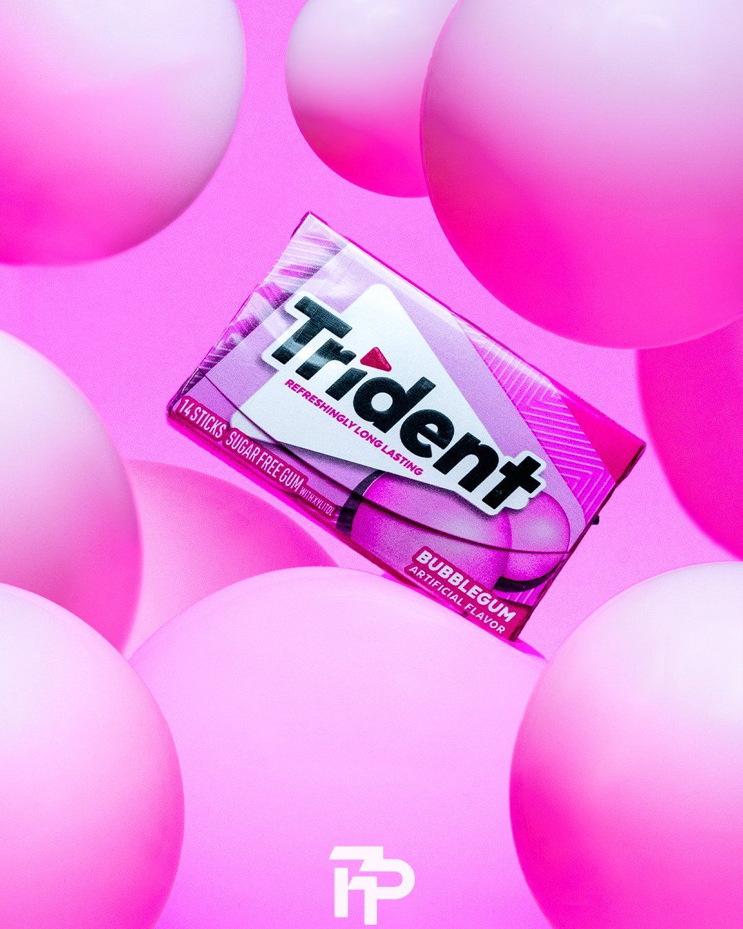 Trident gum pack surrounded by pink gradient bubbles against a pink background.