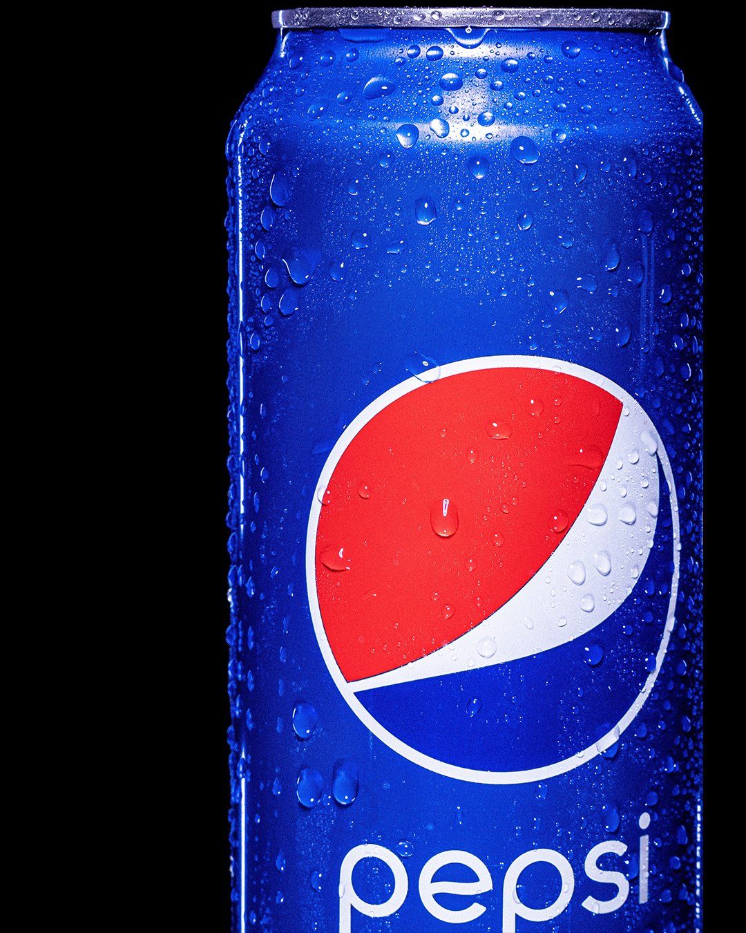 Close-up of a cold Pepsi can with water droplets against black background.