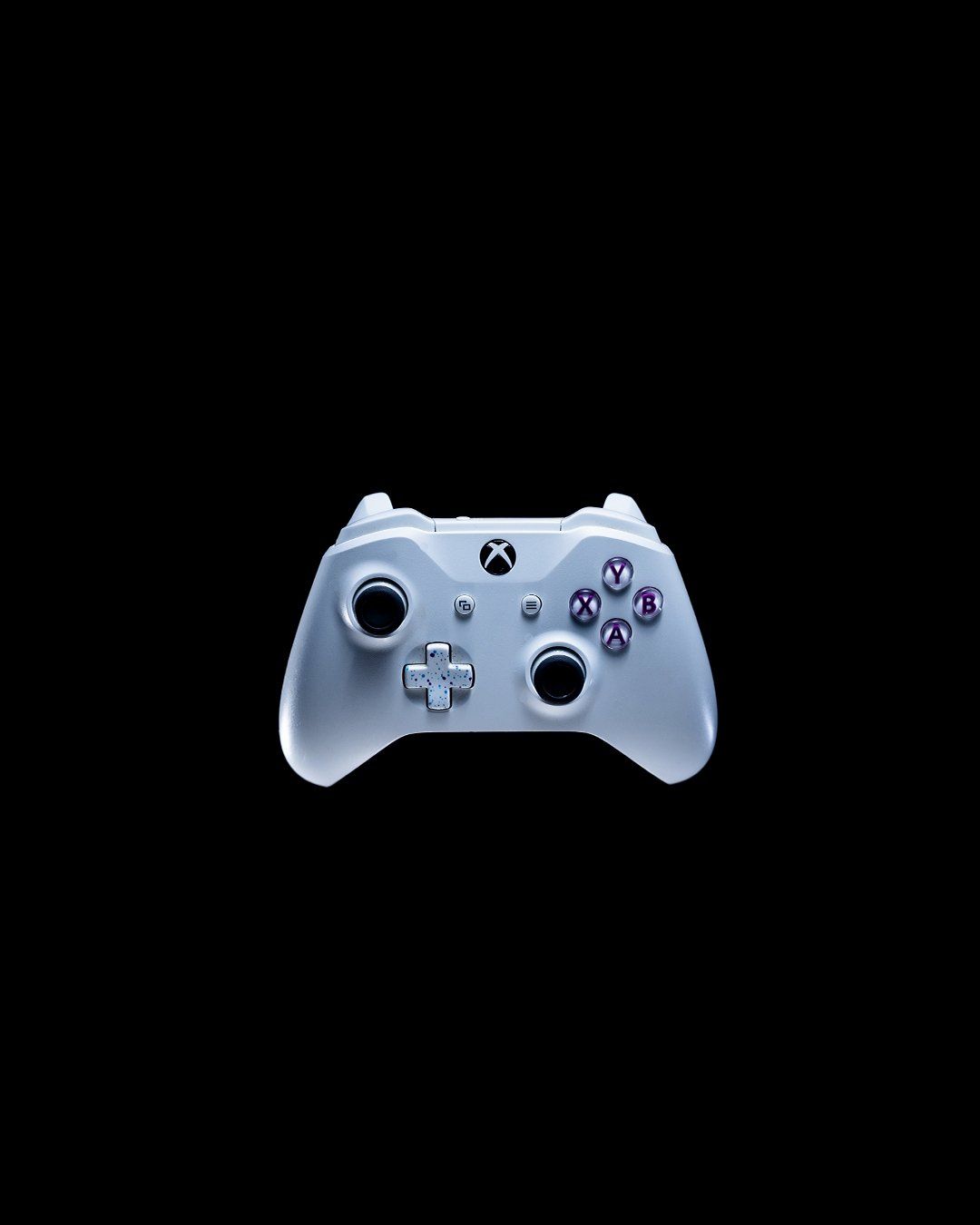 White Xbox controller floating on black background with dramatic lighting.