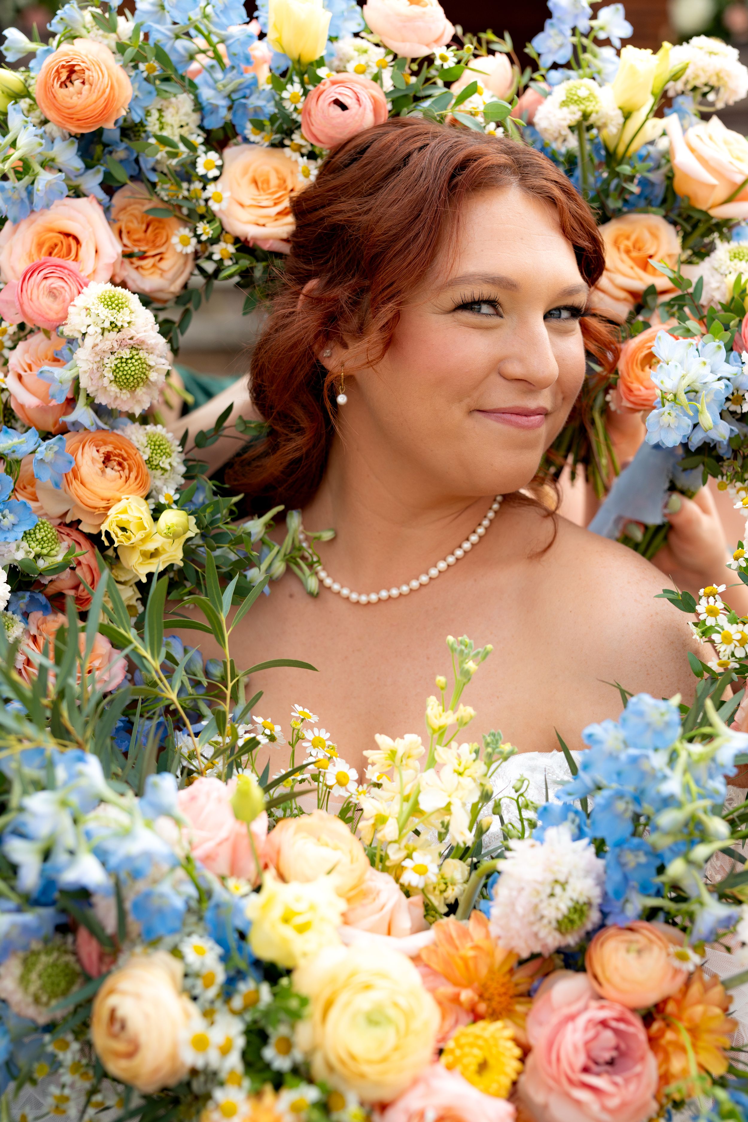 Colorful wedding flowers in peach, yellow and blue arranged artistically with delicate spring blooms.