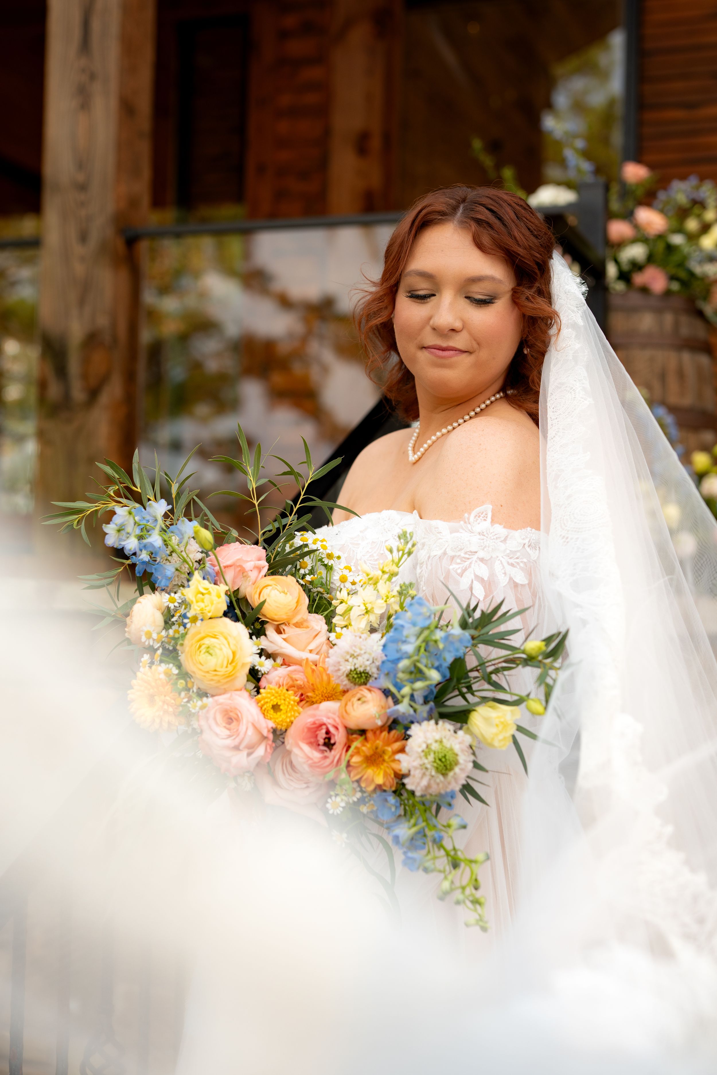 Elegant bridal portrait with delicate pearls and colorful spring bouquet.