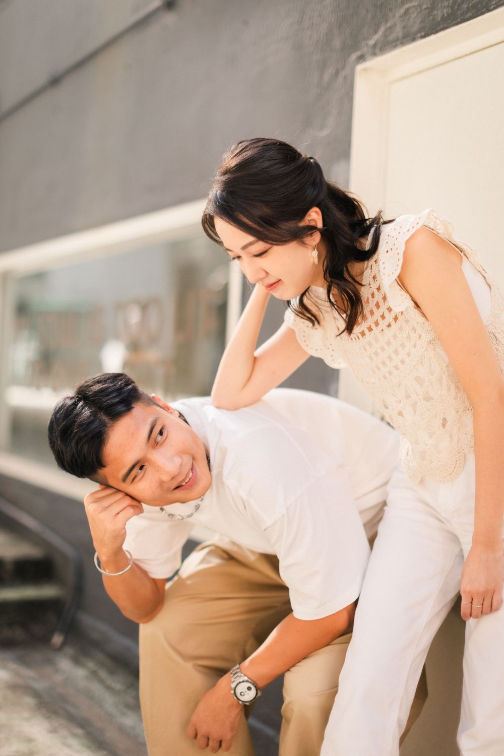 A joyful couple shares a playful moment, woman resting on mans back outdoors.
