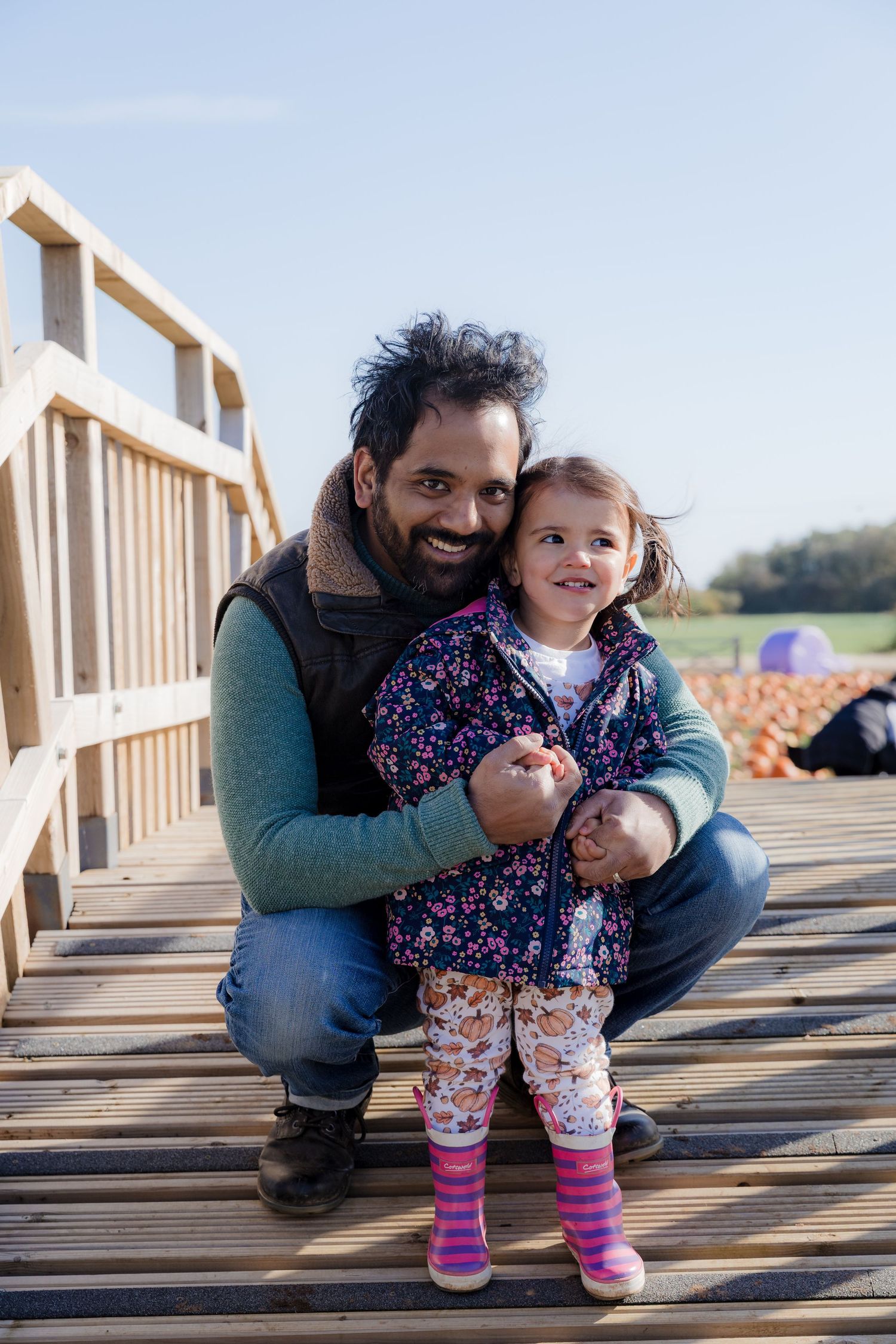 A joyful moment shared on a wooden deck during a bright autumn day.  Photographer. Hull. East Yorkshire. Photography