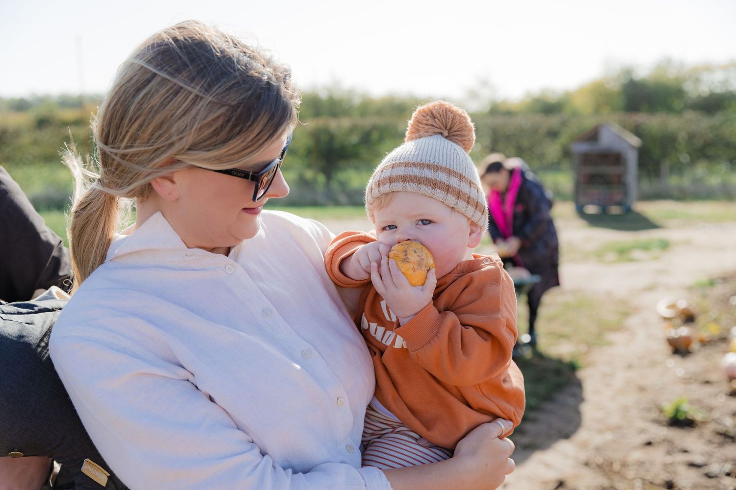 Family enjoying a sunny day together at a pumpkin patch with fall foliage in the background. Photographer. Hull. East Yorkshire. Photography