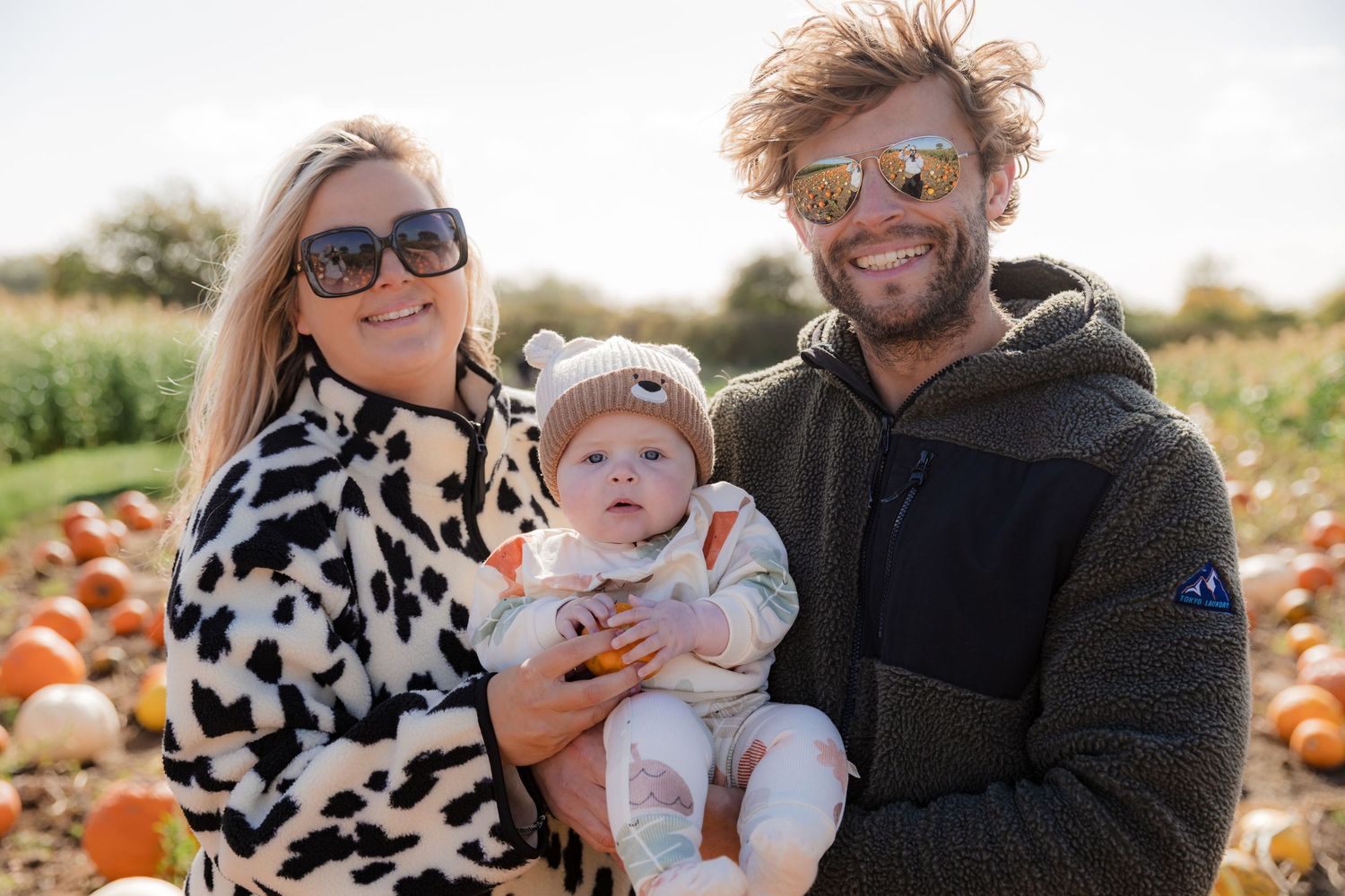 Family enjoying a fall day at a pumpkin patch with their baby in matching cow print outfits. Photographer. Hull. East Yorkshire.