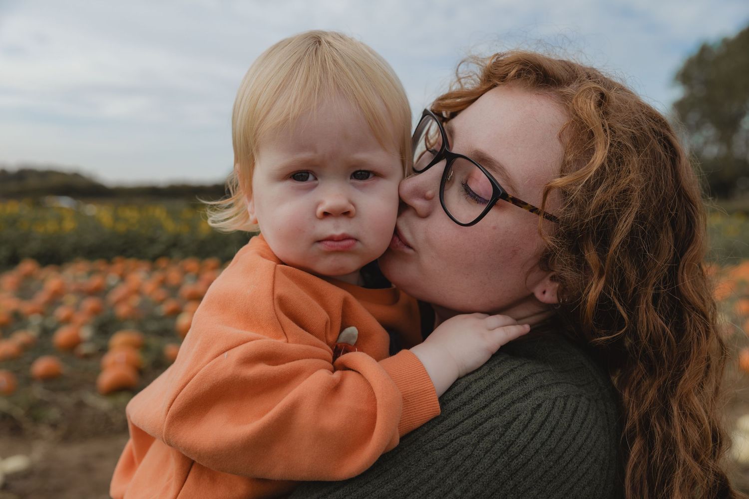 An intimate family moment captured in a pumpkin field during autumn.  Photographer. Hull. East Yorkshire. Photography