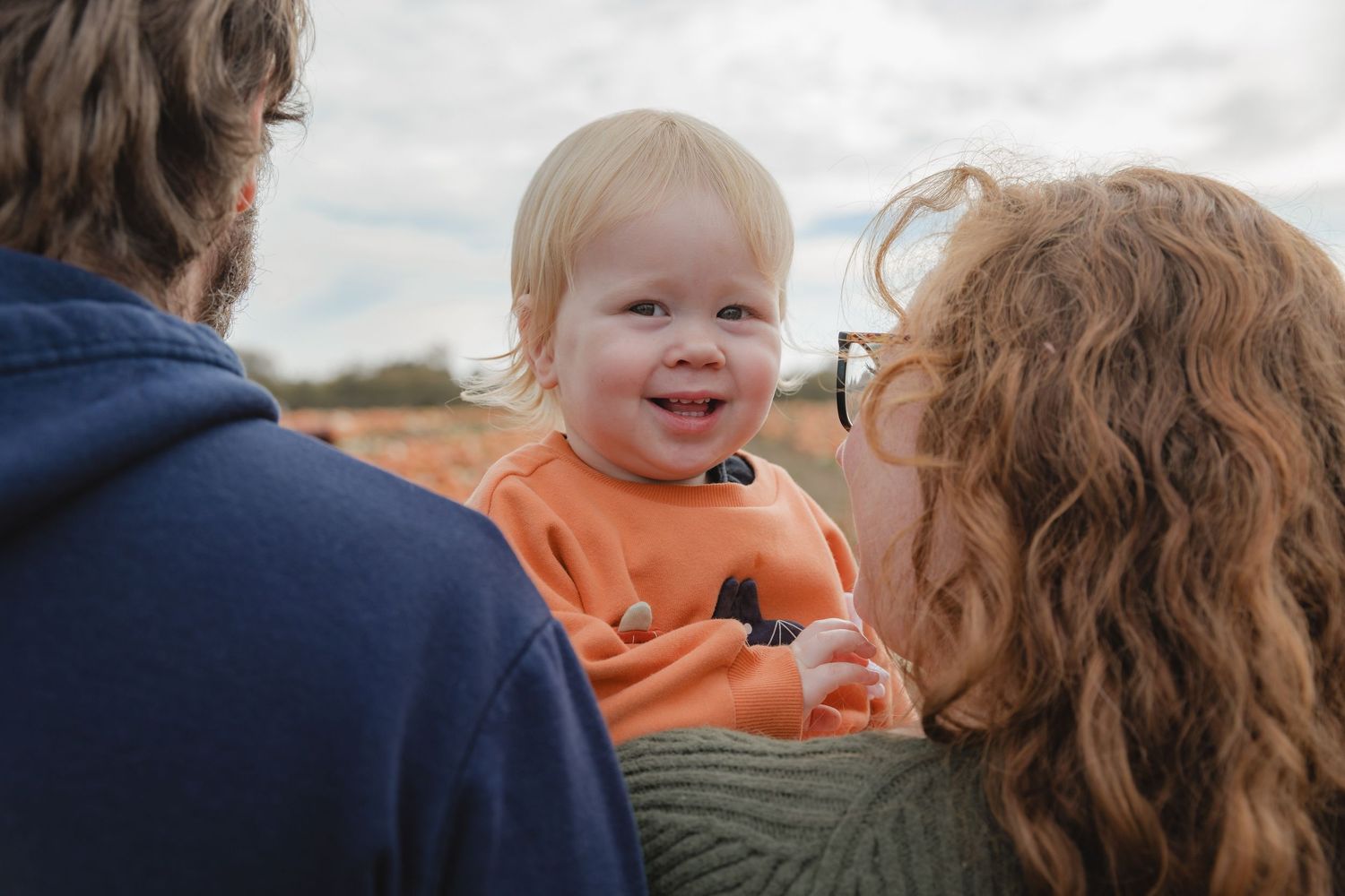 A tender family moment shared among pumpkin patches on a cloudy day.  Photographer. Hull. East Yorkshire. Photography