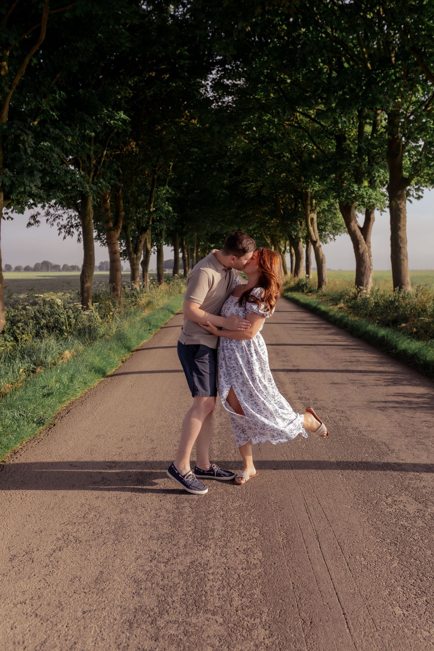 Couple dancing playfully on a tree-lined path in summer sunlight. Photographer. Hull. East Yorkshire. Photography