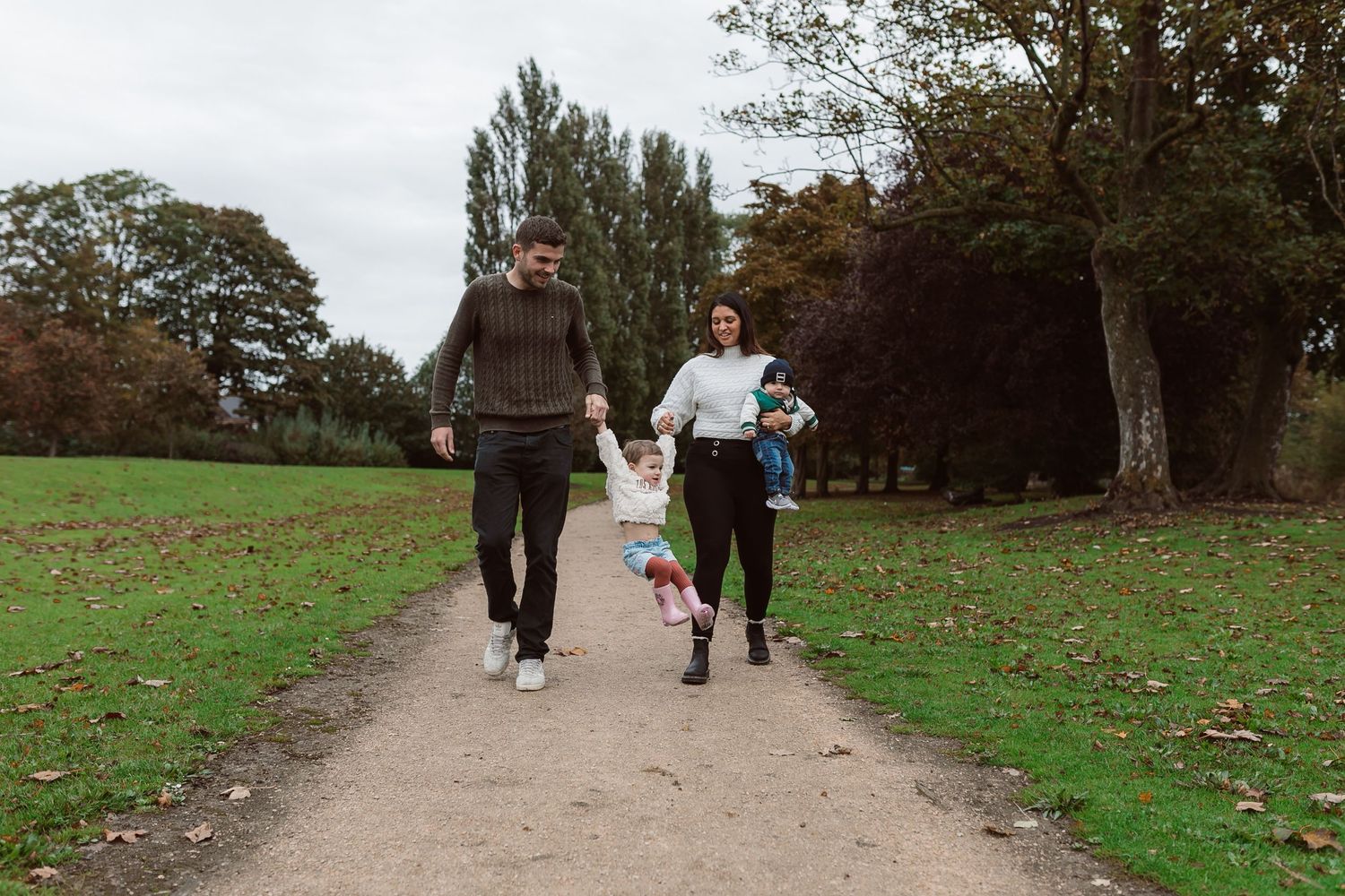 Family walking together on a park trail surrounded by autumn trees and grass. Photographer. Hull. East Yorkshire. Photography