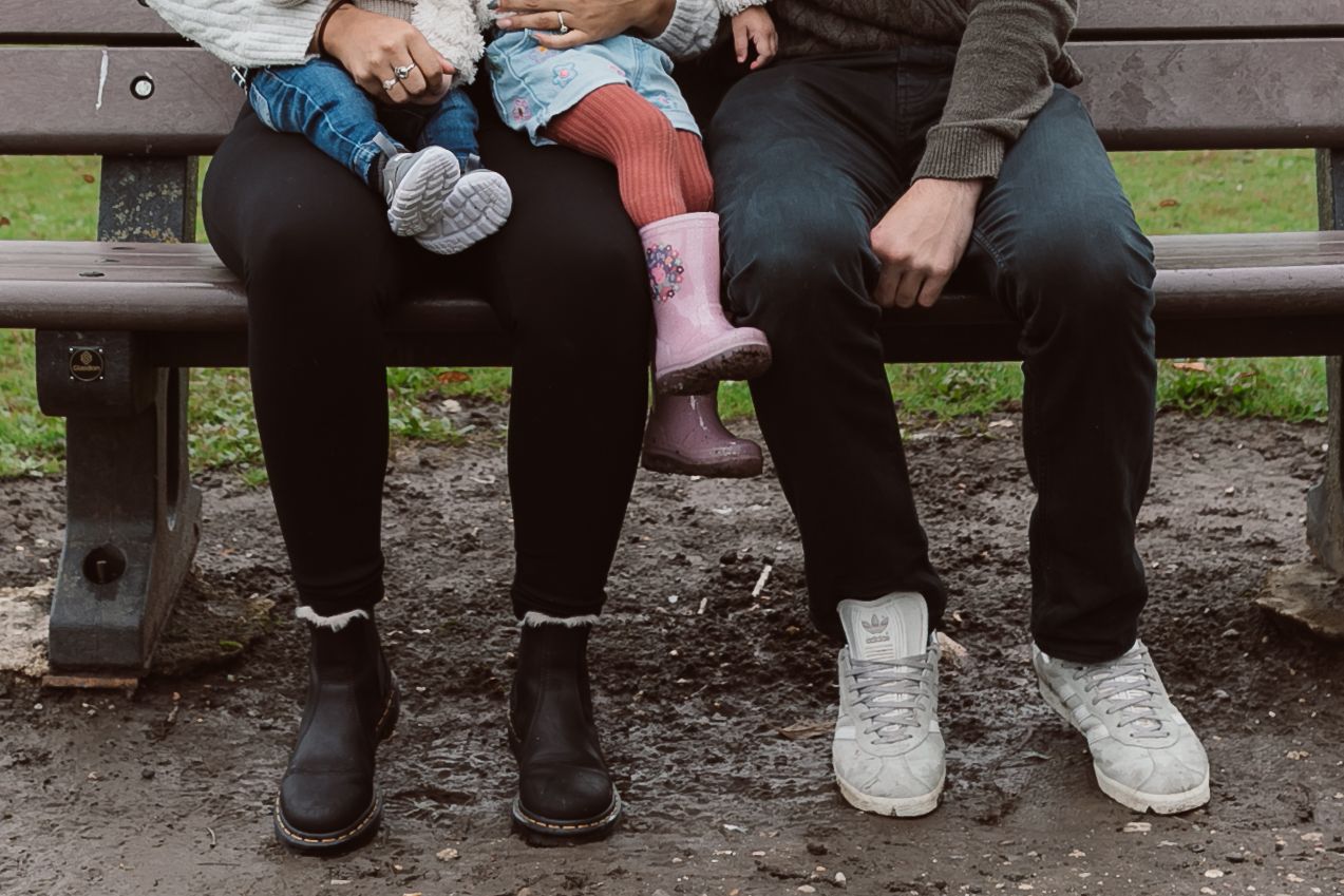 Family members sitting together on a wooden bench in a park setting. Photographer. Hull. East Yorkshire. Photography