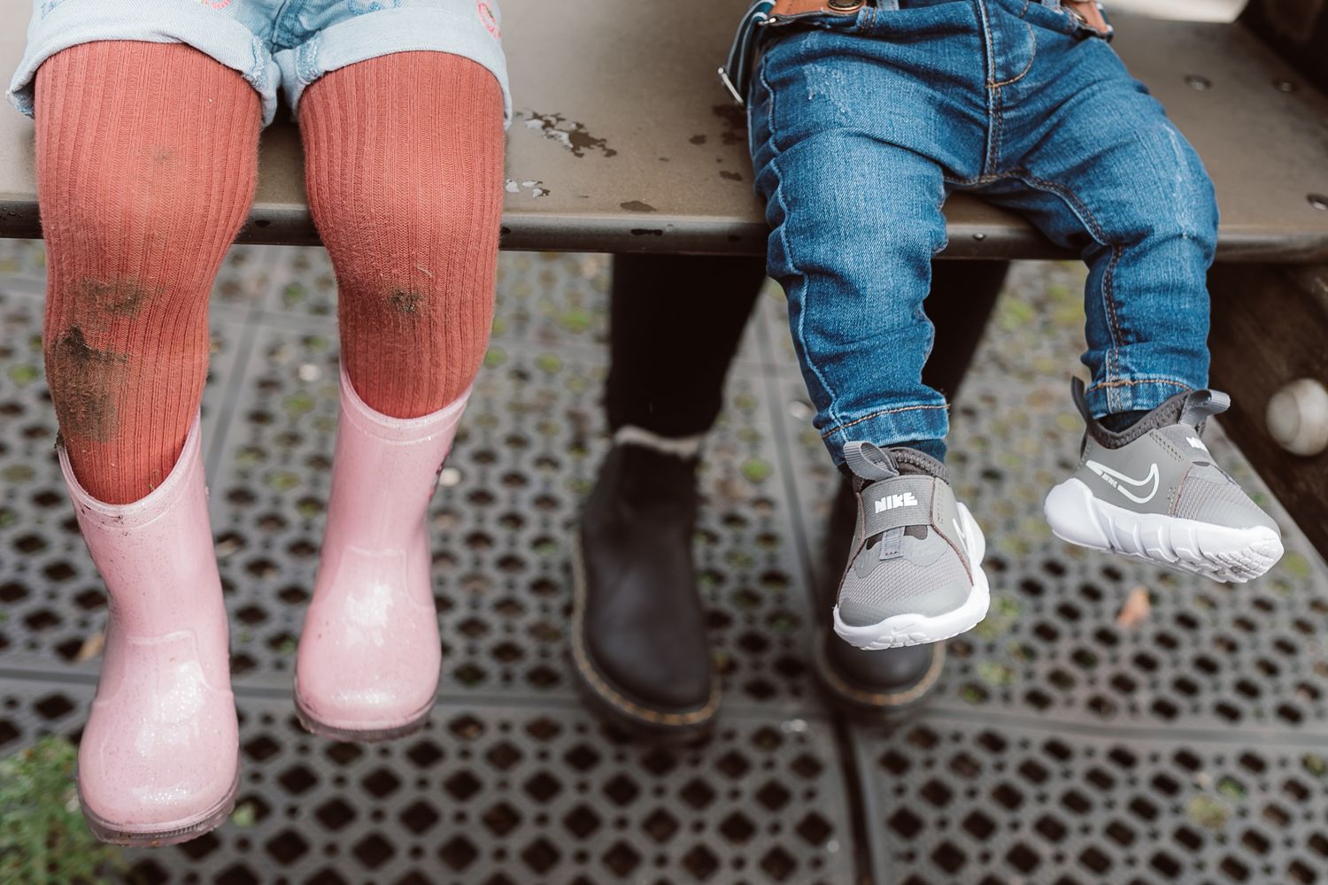 Close-up of feet wearing pink socks and blue jeans while sitting on playground equipment. Photographer. Hull. East Yorkshire. Photography