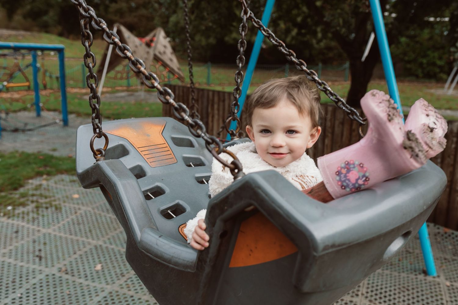 Children enjoying playtime on blue and grey playground swings during an outdoor session. Photographer. Hull. East Yorkshire. Photography