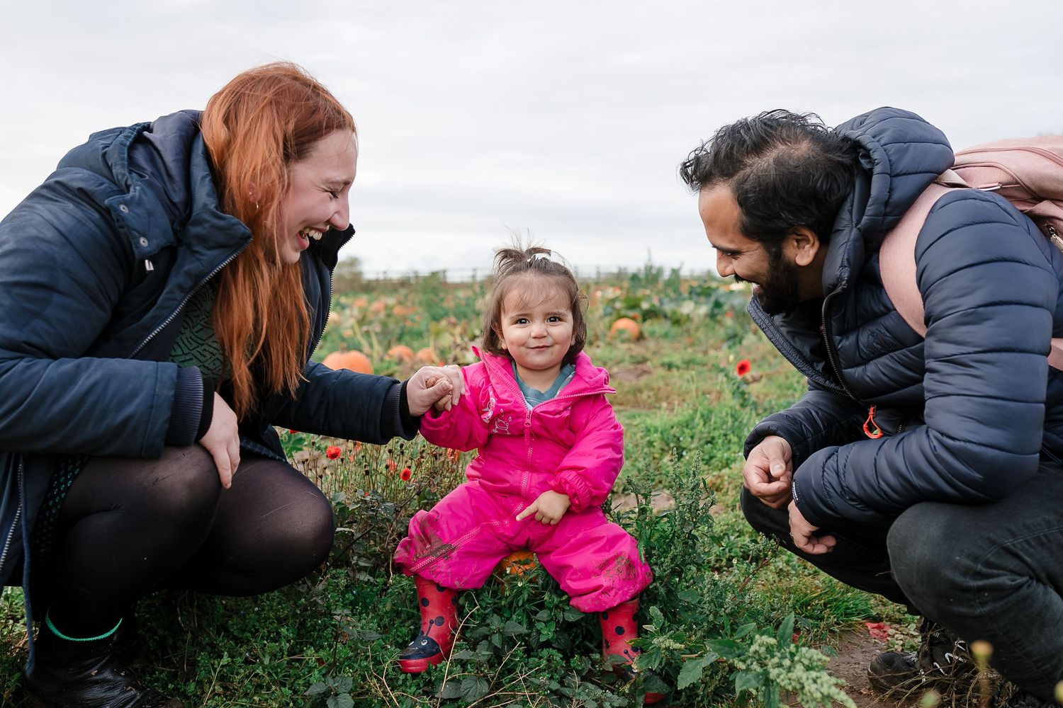 Young child in pink coat explores nature with adults guiding. Photographer. Hull. East Yorkshire. Photography