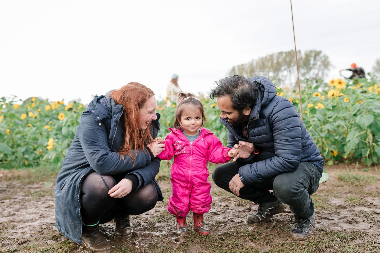 Family enjoying a playful moment together in a sunflower field during autumn. Photographer. Hull. East Yorkshire. Photography