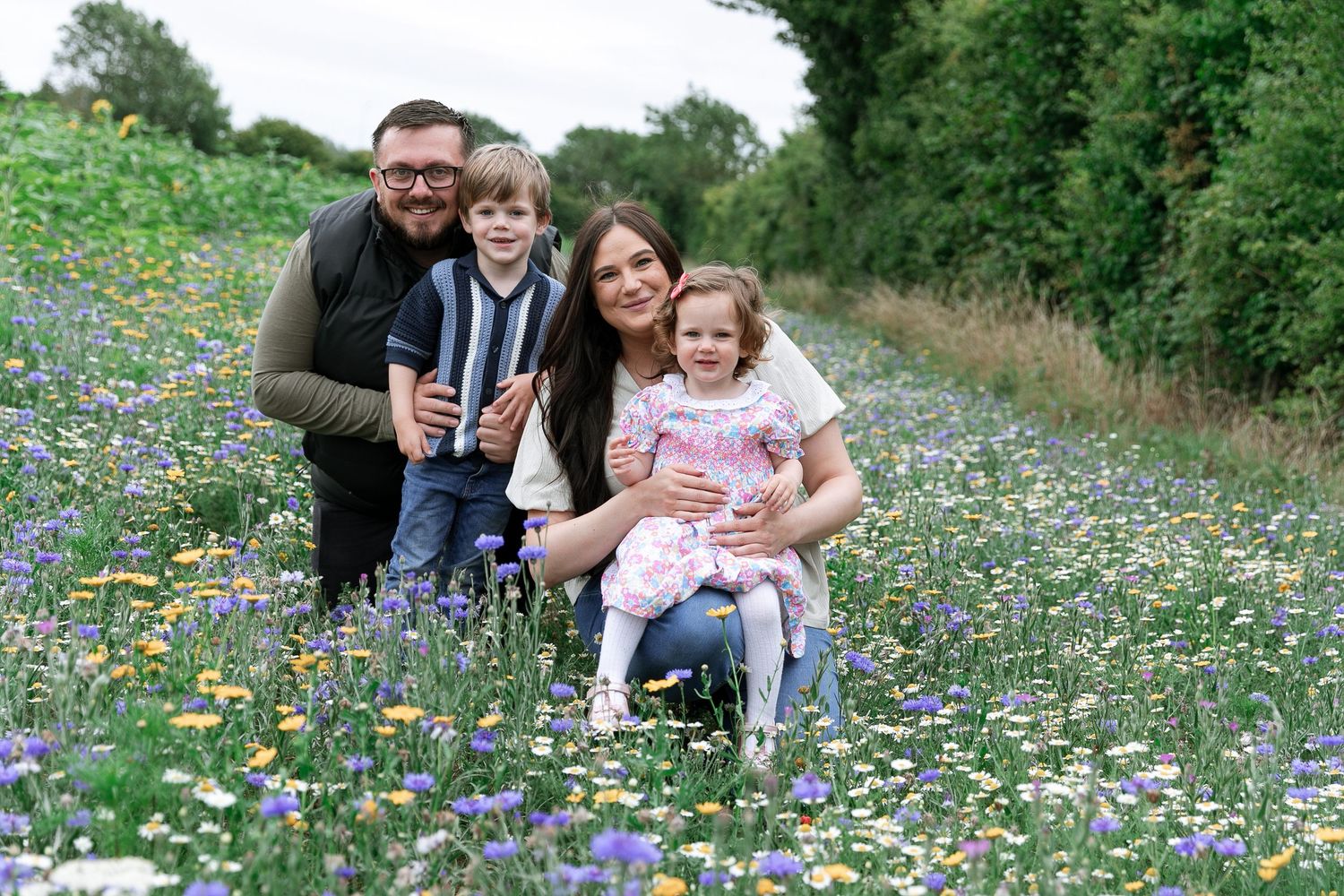 A joyful family moment captured in a meadow filled with colourful wildflowers.  Photographer. Hull. East Yorkshire. Photography