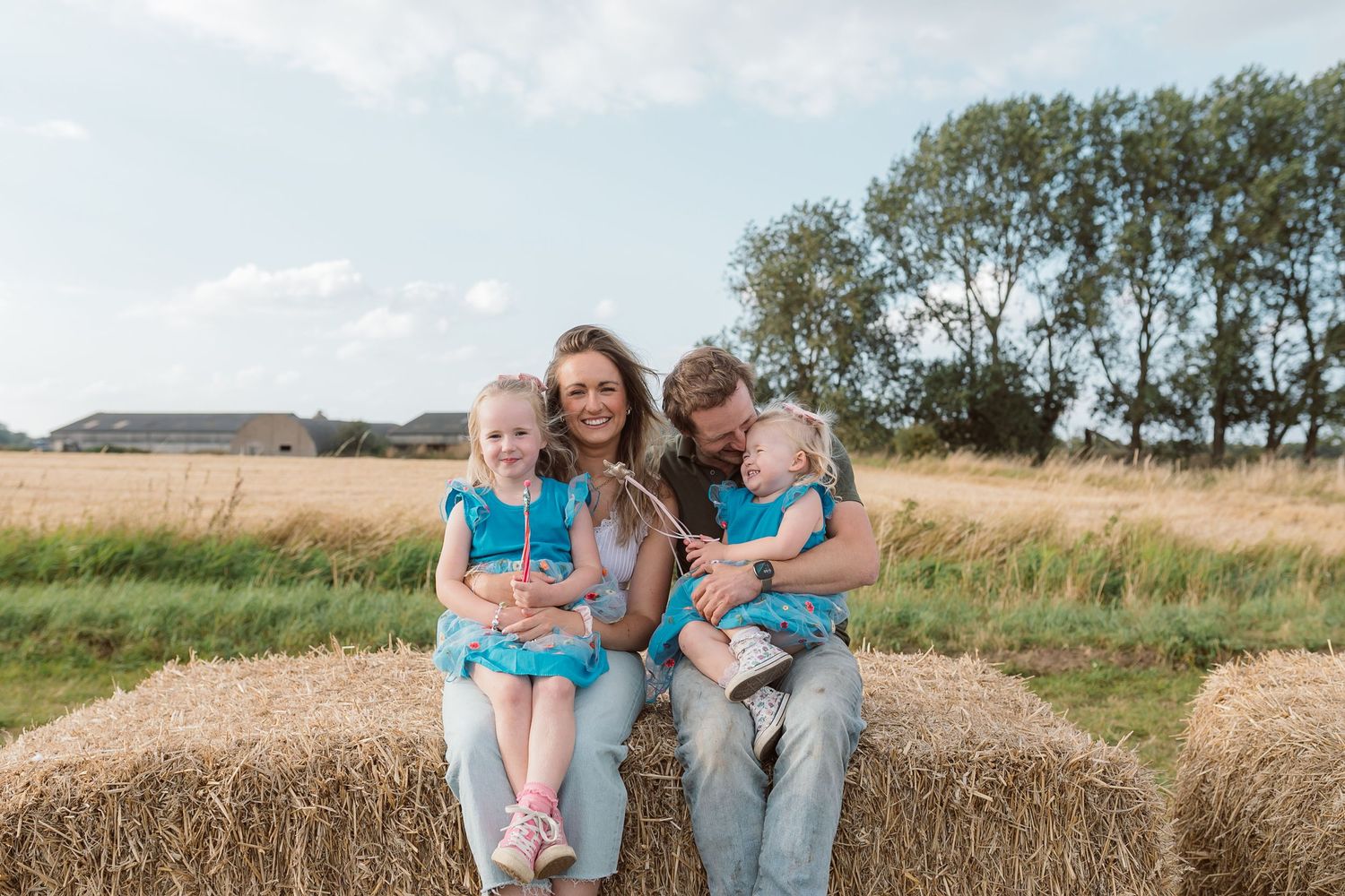 Family sitting together on hay bales in a rustic farm setting. Photographer. Hull. East Yorkshire. Photography