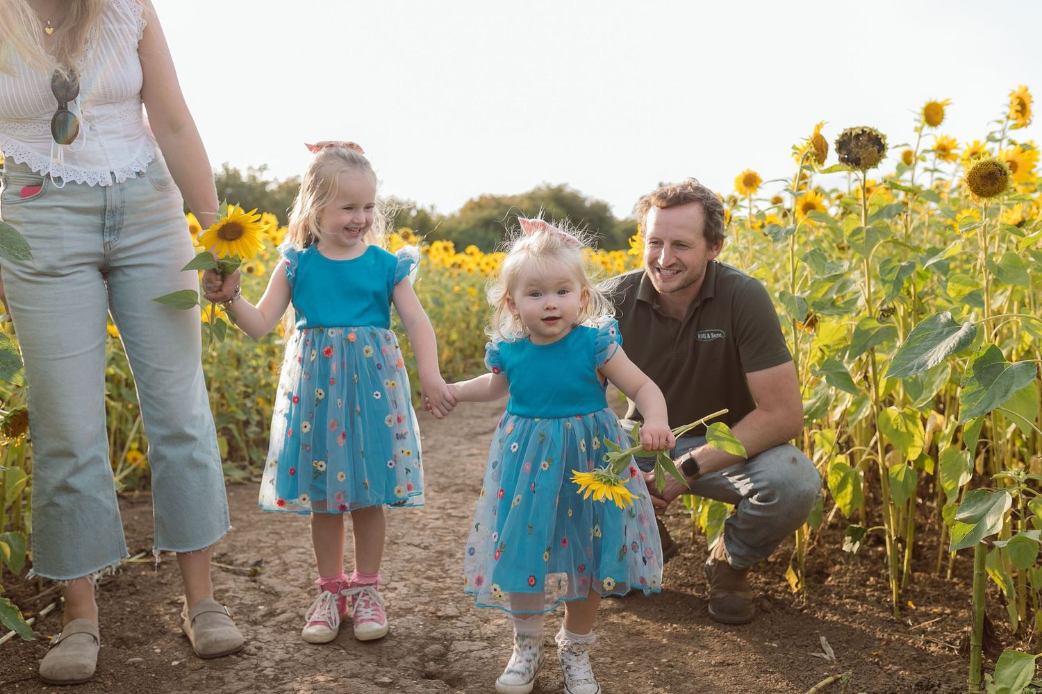 Family enjoying time together in sunflower field wearing matching blue outfits. Photographer. Hull. East Yorkshire. Photography